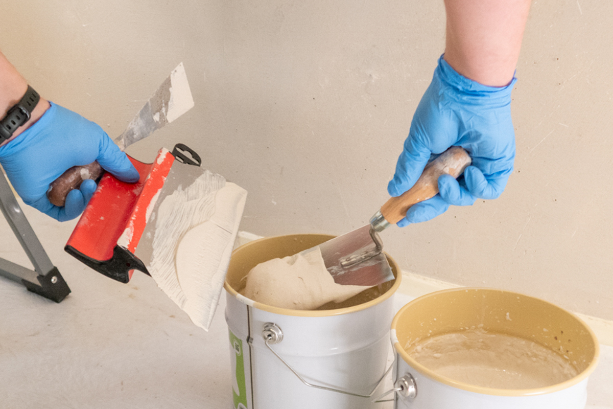 met een troffel beton cire aanbrengen op een pleisterspaan